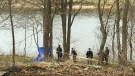 Police officers and forensic investigators are seen on the bank of the Grand River in Cambridge on April 11, 2022. (Dan Lauckner/CTV Kitchener)