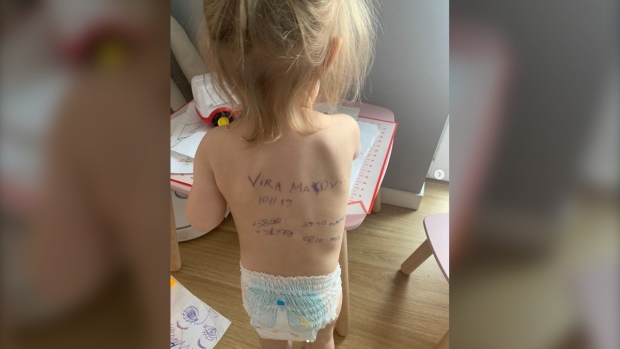 Ibu Ukraina menulis info kontak di punggung anak