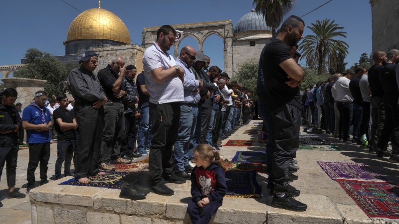 Palestinian men pray on the second Friday of the holy Islamic month of Ramadan in front of the Dome of the Rock shrine at the Al Aqsa Mosque compound in Jerusalem's Old City, Friday, April 15, 2022. (AP Photo/Mahmoud Illean)