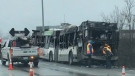 Workers assess the shell of a burned STO bus on the side of the Highway in Gatineau after a fire Tuesday, Apr. 19, 2022. 