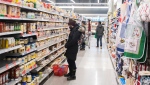 People shop at a grocery store in Montreal, Sunday, Dec. 19, 2021, as the COVID-19 pandemic continues in Canada and around the world. (THE CANADIAN PRESS/Graham Hughes)