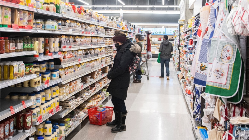 People shop at a grocery store in Montreal, Sunday, Dec. 19, 2021, as the COVID-19 pandemic continues in Canada and around the world. (THE CANADIAN PRESS/Graham Hughes)