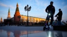 Youth ride scooters in Manezhnaya Square near Red Square and the Kremlin after sunset in Moscow, Russia, Wednesday, April 20, 2022. (AP Photo/Alexander Zemlianichenko)