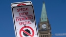 A temporary no-stopping sign is fixed with paper clips to a road sign near Parliament Hill, Thursday, April 28, 2022 in Ottawa. The area is part of a motorized vehicle exclusion zone set by the Ottawa Police Service. (Adrian Wyld/THE CANADIAN PRESS)