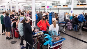 In this file photo, travellers wait in line at a Sunwing Airlines check-in desk at Trudeau Airport in Montreal, Wednesday, April 20, 2022. THE CANADIAN PRESS/Graham Hughes