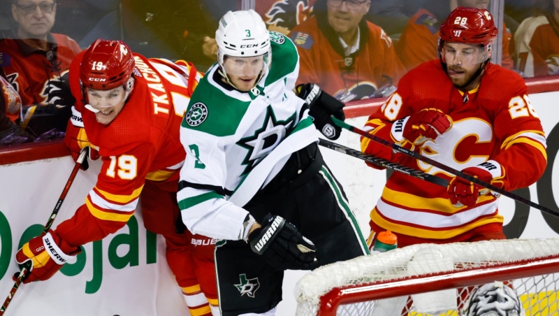 Dallas Stars defenceman John Klingberg (3) checks Calgary Flames left wing Matthew Tkachuk (19) as Flames centre Elias Lindholm (28) looks on during first period NHL playoff hockey action in Calgary, Tuesday, May 3, 2022. (THE CANADIAN PRESS/Jeff McIntosh)