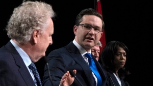 Conservative leadership candidate Pierre Poilievre gestures towards Jean Charest as Roman Baber, left, Scott Aitchison and Leslyn Lewis, right, debate at the Canada Strong and Free Network conference, in Ottawa, Thursday, May 5, 2022. THE CANADIAN PRESS/Adrian Wyld
