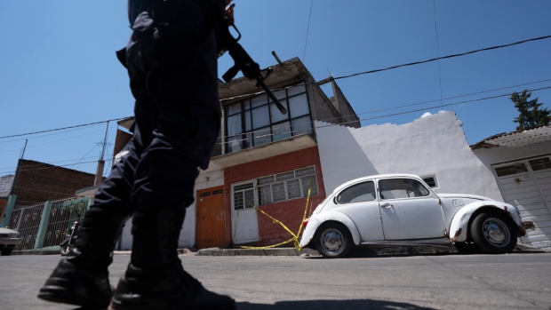 In this file photo, a police officer stands guard outside the red brick house where journalist Armando Linares was shot dead, in Zitacuaro, Michoacan state, Mexico, Wednesday, March 16, 2022. Linares, who was shot dead at the home on Tuesday, was the eighth Mexican journalist to be killed so far this year. (AP Photo/Marco Ugarte)