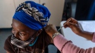 A woman is vaccinated against COVID-19 at the Lenasia South Hospital, near Johannesburg. Wednesday, Dec. 1, 1021. (AP Photo/ Shiraaz Mohamed)