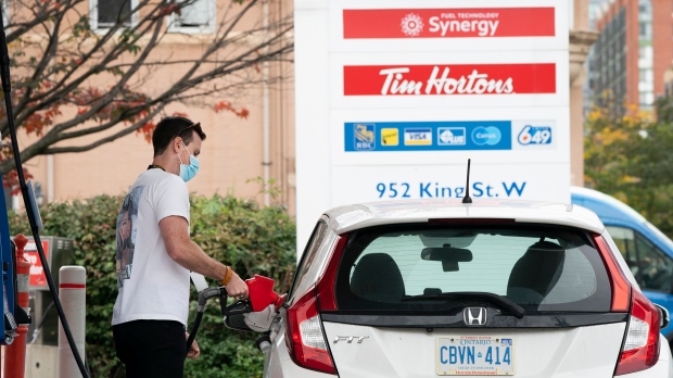 FILE - A man fills his vehicle with gas in Toronto on Friday, October 8, 2021. THE CANADIAN PRESS/Nathan Denette 