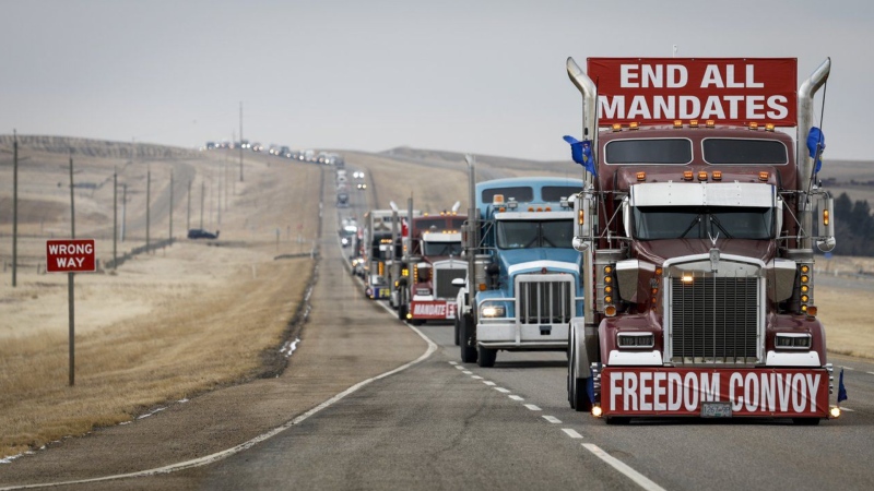 Demonstrators against COVID-19 vaccine mandates and other restrictions leave in a truck convoy after blocking the highway at the busy U.S. border crossing near Coutts, Alta., on Feb. 15, 2022. (THE CANADIAN PRESS/Jeff McIntosh)