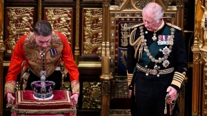Prince Charles, right, watches as the Imperial Crown is removed after he read the Queen's speech in the House of Lords Chamber, in London, on May 10, 2022. (Ben Stansall / Pool Photo via AP) 