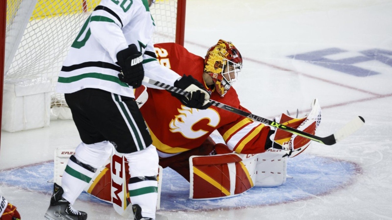 Dallas Stars defenceman Ryan Suter, left, has his shot grabbed by Calgary Flames goalie Jacob Markstrom during second period NHL playoff hockey action in Calgary, Tuesday, May 3, 2022. Markstrom was among three Vezina Trophy finalists named today.(THE CANADIAN PRESS/Jeff McIntosh)