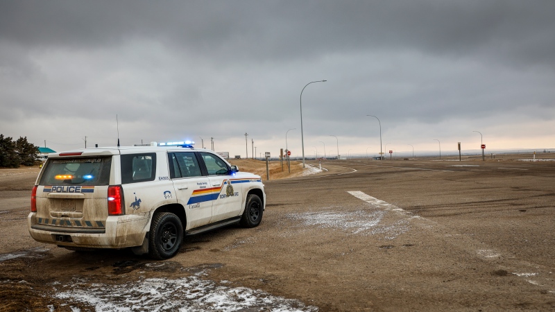 A police vehicle looks out over an empty highway after anti-COVID-19 vaccine mandate demonstrators left following their blockade of the highway at the busy U.S. border crossing in Coutts, Alta., Tuesday, Feb. 15, 2022. (THE CANADIAN PRESS)