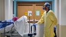 A health-care worker wearing PPE transports a patient in the dialysis unit. THE CANADIAN PRESS/Nathan Denette
