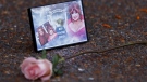 A photograph of Naomi Judd lays with a rose outside the Country Music Hall of Fame, on May 1, 2022. (Wade Payne / Invision / AP)