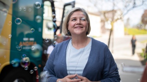 Ontario NDP Leader Andrea Horwath walks through a cloud of bubbles on the sidewalk as she campaigns at the Dog-Eared Cafe in Paris, Ont., Thursday, May 12, 2022. THE CANADIAN PRESS/Nick Iwanyshyn