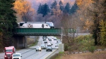 The northbound Amtrak Cascades train rolls across the Interstate 5 overpass in DuPont, Wash., on Thursday, Nov. 18, 2021. The overpass was the site of the fatal train derailment in December 2018. (Tony Overman /The News Tribune via AP)