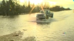 A truck drives through a flooded road in the RM of Ritchot on May 12, 2022. (Source: CTV News Winnipeg)