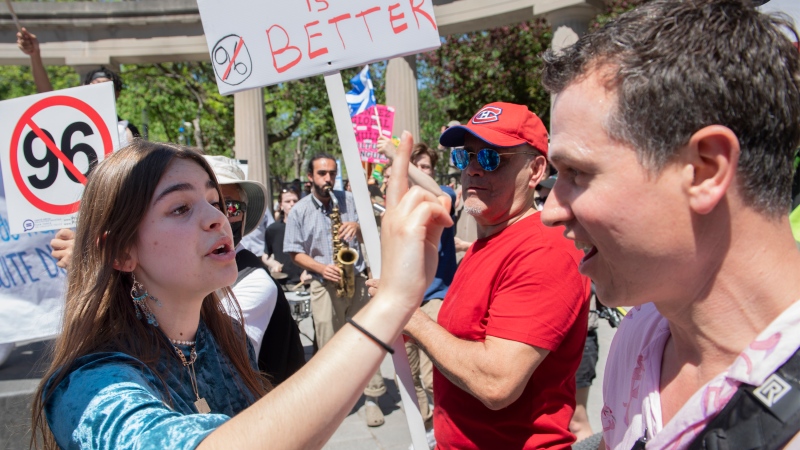 An anti Bill 96 protester, right, is confronted by a pro-supporter during a demonstration in Montreal, Saturday, May 14, 2022. THE CANADIAN PRESS/Graham Hughes
