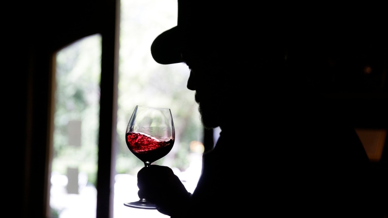 A man swirls a glass of wine during a virtual online tasting and tour of the historic Buena Vista Winery in Sonoma, Calif., Wednesday, April 1, 2020. (THE CANADIAN PRESS/AP/Eric Risberg)