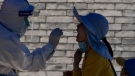 A resident gets a throat swab during a mass COVID-19 test in Beijing, China, on May 16, 2022. (Andy Wong / AP)