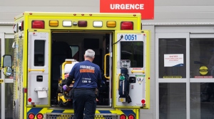 A paramedic loads his stretcher back into the ambulance after bringing a patient to the emergency room at a hospital in Montreal on April 14, 2022. (THE CANADIAN PRESS/Ryan Remiorz)