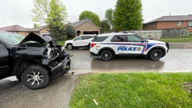 A black pick-up truck hit the back of a school bus while students were waiting to board on May 16, 2022. (Sean Irvine/CTV News London)