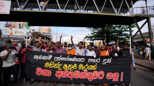 Members of Socialist Youth Union shout slogans and march towards Sri Lanka's police headquarters carrying a banner demanding the arrest of former prime minister Mahinda Rajapkasa for allegedly assaulting anti government protesters in Colombo, Sri Lanka, Monday, May 16, 2022. (AP Photo/Eranga Jayawardena)
