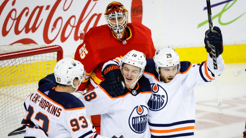 Edmonton Oilers' Leon Draisaitl, right, celebrates his goal with teammates Ryan Nugent-Hopkins, left, and Zach Hyman, centre, as Calgary Flames goalie Jacob Markstrom looks on during second period NHL hockey action in Calgary, Saturday, March 26, 2022.THE CANADIAN PRESS/Jeff McIntosh