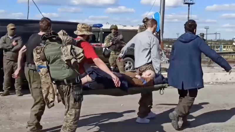 In this photo taken from video released by the Russian Defense Ministry Press Service on Tuesday, May 17, 2022, Ukrainian servicemen carry a wounded comrade as they are being evacuated from the besieged Azovstal steel plant in Mariupol, Ukraine.  (Russian Defense Ministry Press Service via AP)