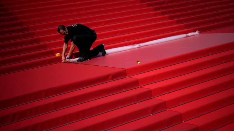 Crew members install the red carpet at the Palais des Festivals ahead of the opening day of the 75th Cannes international film festival, on May 17, 2022. (Daniel Cole / AP) 
