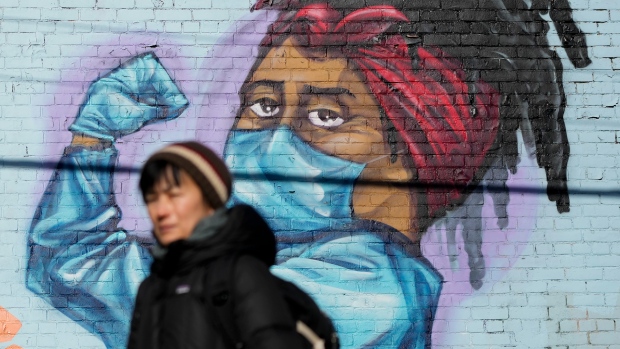 A person walks past a mural during the COVID-19 pandemic in Toronto on Tuesday, November 23, 2021. THE CANADIAN PRESS/Nathan Denette