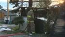 A CFD member douses the side of a home on Simons Crescent N.W. on May 17 during a fire response.