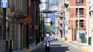 In this photo released by Xinhua News Agency, a resident takes photos on a quiet street in Shanghai on Tuesday, May 17, 2022.  (Jin Liwang/Xinhua via AP)