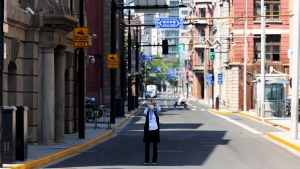 In this photo released by Xinhua News Agency, a resident takes photos on a quiet street in Shanghai on Tuesday, May 17, 2022.  (Jin Liwang/Xinhua via AP)