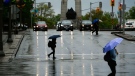 People cross Elgin Street as rain falls in Ottawa, on Tuesday, May 17, 2022. (Justin Tang/THE CANADIAN PRESS)