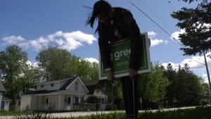 Simcoe North Green Party candidate Krystal Brooks puts her election sign on a lawn in Orillia, Ont. on Tues., May 17, 2022 (Kraig Krause/CTV News)
