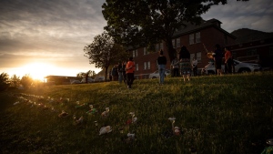A group of youths lead a group drumming and singing at sunset outside the former Kamloops Indian Residential School, to honour the lives of those suspected to be buried in unmarked graves near the facility, in Kamloops, B.C., June 4, 2021. THE CANADIAN PRESS/Darryl Dyck