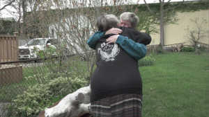 Nancy Allen hugs Brenda Hill on May 18, 2022 after Hill helped Allen reunite with her bear statue that was stolen from her front garden last week. (Lisa Clifford/CTV News London)
