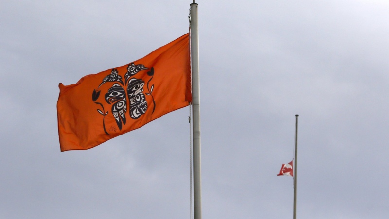The Canadian flag hangs half-mast as a ceremonial flag is raised to honour victims of the residential school system during the Xe xe Smun’ eem-Victoria Orange Shirt Day Every Child Matters ceremony at Centennial Square in Victoria, Sept. 30, 2021. THE CANADIAN PRESS/Chad Hipolito