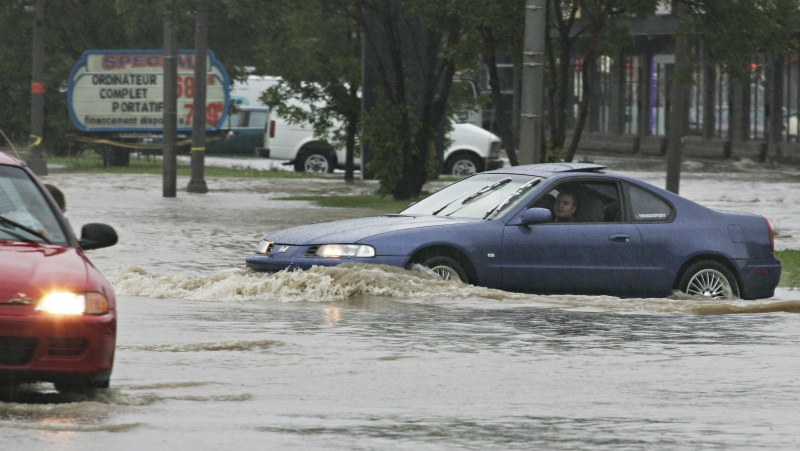 File photo of motorists drive along a flooded street in Quebec City. (CP PHOTO/Jacques Boissinot)
