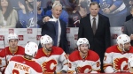 Calgary Flames head coach Darryl Sutter, left, talks to his players in third period NHL pre-season game action against the Winnipeg Jets in Winnipeg on Wednesday, October 6, 2021. Sutter is among the three finalists for the Jack Adams Award, presented annually to the National Hockey League's coach of the year. (THE CANADIAN PRESS/John Woods)