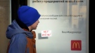 A boy walks past a 'No War!' sign stuck to a window of McDonald's restaurant with a restaurant's closing notice in St. Petersburg, Russia, Tuesday, March 15, 2022. (AP Photo)
