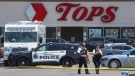Police walk outside the Tops grocery store in Buffalo, N.Y., on May 15, 2022. (Joshua Bessex / AP)