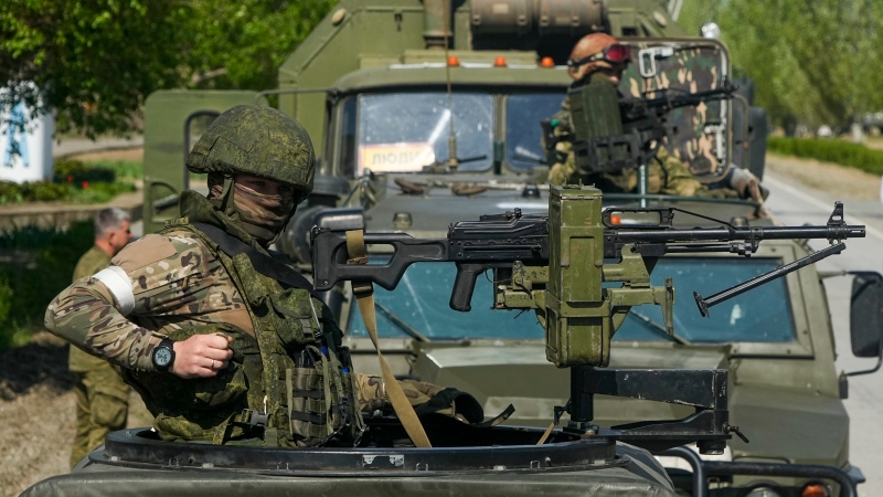 Armed Russian servicemen stand atop their military vehicles in Enerhodar, Zaporizhzhia region, in territory under Russian military control, southeastern Ukraine, Sunday, May 1, 2022. (AP Photo)