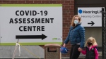 People walk past a COVID-19 assessment centre outside a hospital in Toronto on Monday, April 4, 2022. THE CANADIAN PRESS/Nathan Denette