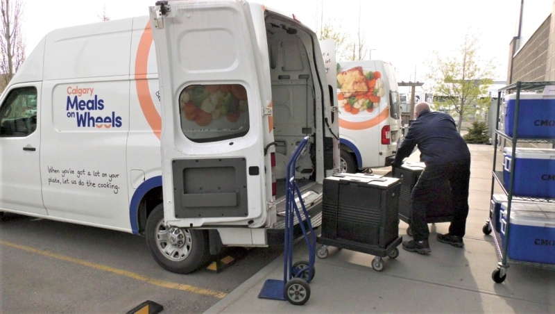 A Meals on Wheels driver loads a company van to deliver lunches to clients. 