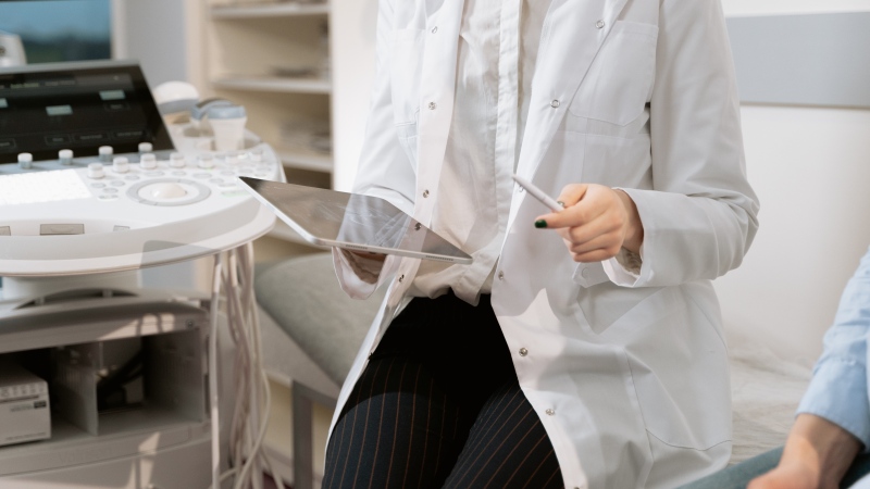 A gynecologist is seen sitting near medical equipment. (MART PRODUCTION / Pexels)
