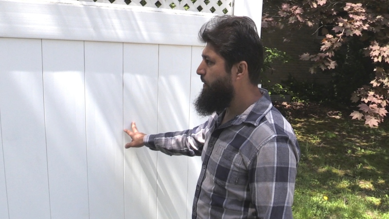 Ahmad Jawad shows where ‘KKK’ was spray-painted on the fence behind his home on Hawthorne Road in London, Ont. on Thursday, May 19, 2022. (Daryl Newcombe/CTV News London)